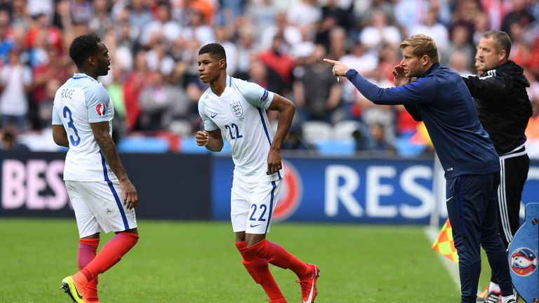 A team member (R) gestures next to England's defender Danny Rose (L) and England's forward Marcus Rashford during the Euro 2016 group B football match betw