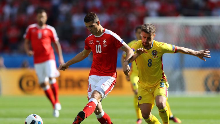 Mihai Pintilii of Romania chases down Granit Xhaka of Switzerland 