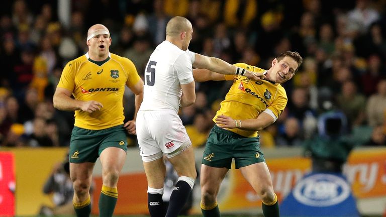 Mike Brown of England pushes Bernard Foley of the Wallabies