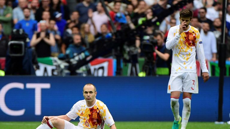 Spain's midfielder Andres Iniesta (L) and Spain's defender Gerard Pique react during Euro 2016 round of 16 football match between Italy and Spain at the St
