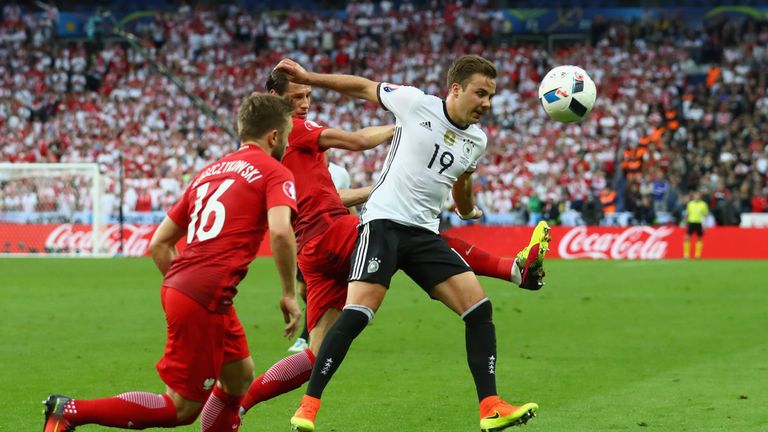 Mario Gotze (right) of Germany battles for the ball with Jakub Blaszczykowski (l) of Poland and his team mate Grzegorz Krychowiak (partially obscured)