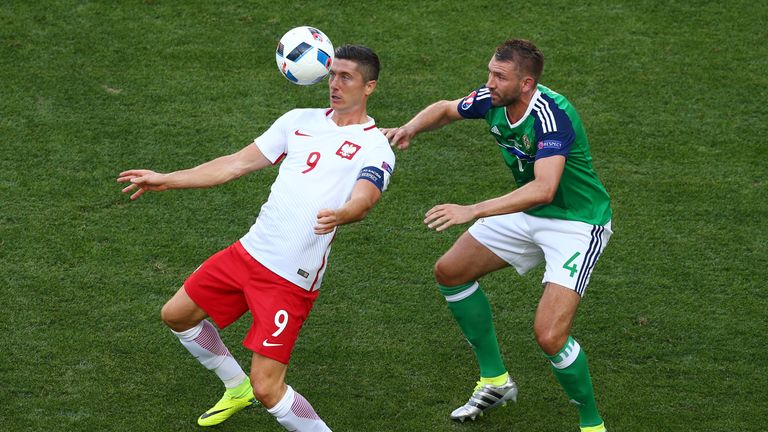 NICE, FRANCE - JUNE 12: Robert Lewandowski of Poland controls the ball under pressure of Gareth McAuley of Northern Ireland during the UEFA EURO 2016 Group