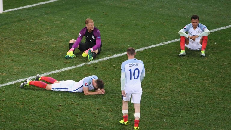Wayne Rooney (2nd R) of England walks to console Gary Cahill (1st L), Joe Hart (2nd L) and Dele Alli (1st R) after their defeat against Iceland