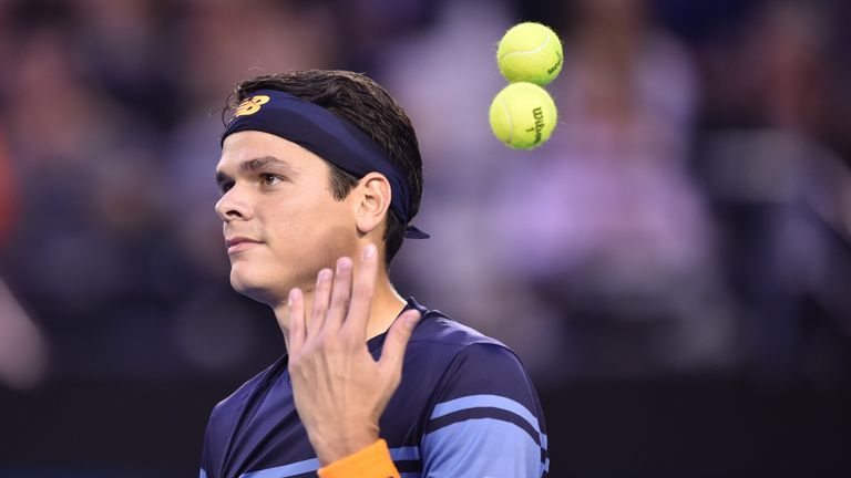 Milos Raonic throws the tennis balls during his men's singles semi-final match against Andy Murray