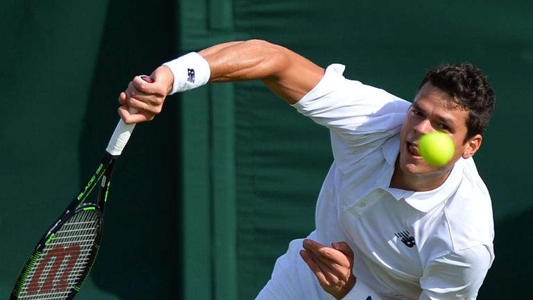 Milos Raonic serves against Pablo Carreno Busta during their men's singles first round match at Wimbledon