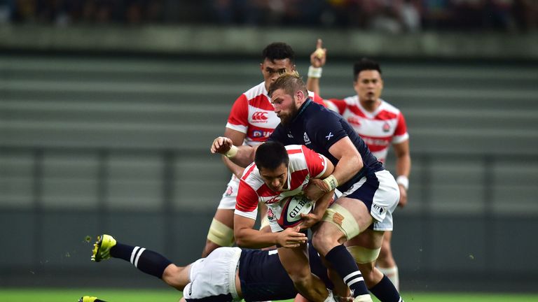 Tim Bennetts of Japan is tackled during Saturday's match with Scotland