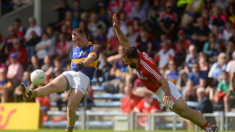 Peter Acheson of Tipperary scores a point under pressure from Colm O'Driscoll of Cork