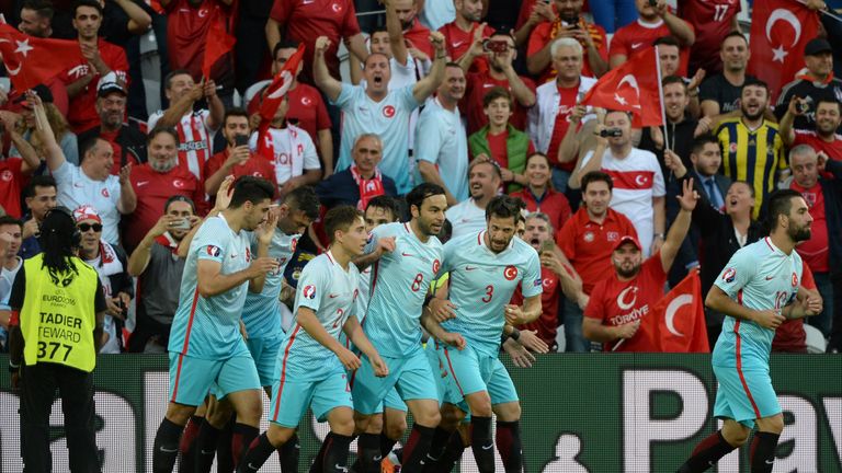 Turkey's forward Burak Yilmaz (2ndL) is congratulated by teammates