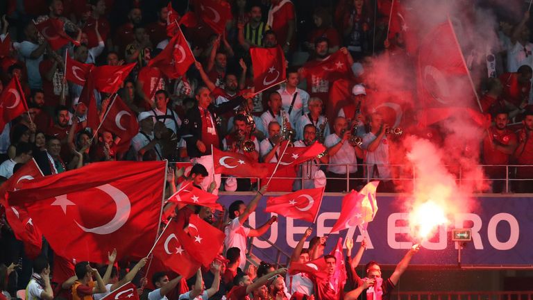 Turkey supporters wave the national flags and a flare during the Euro 2016 group D football match between Spain and Turkey at the Allianz Riviera stadium i