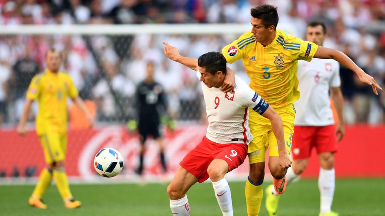 Robert Lewandowski vies for the ball with Yevhen Khacheridi 