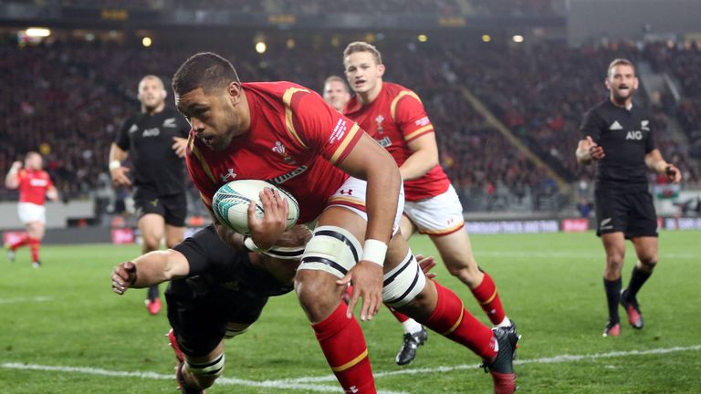 New Zealand All Blacks Sam Cane attempts to tackle Wales' Taulupe Faletau (C) as he heads for a try during the rugby Test match between the New Zealand All