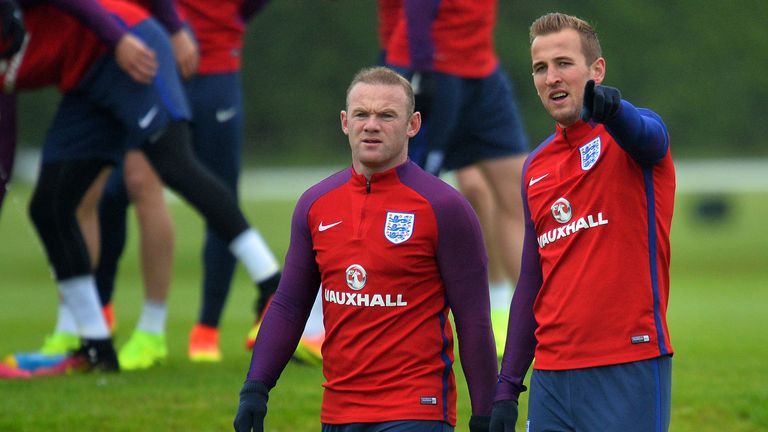 England's striker Harry Kane (R) gestures as he talks with England's striker Wayne Rooney during a team training session in Watford, north of London, on Ju