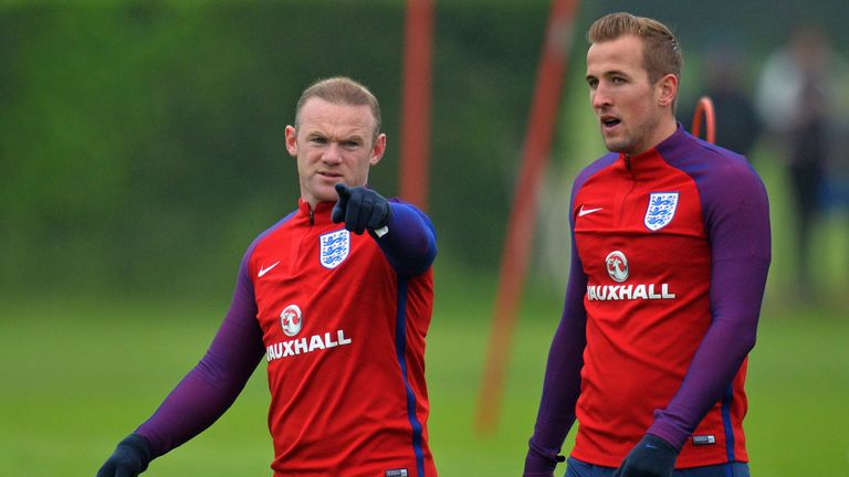 England striker Wayne Rooney (L) gestures as talks with Harry Kane