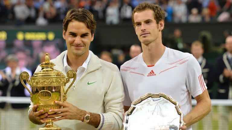 Roger Federer (L) poses with the trophy with loser Andy Murray (R) after his men's singles final at Wimbledon 2012