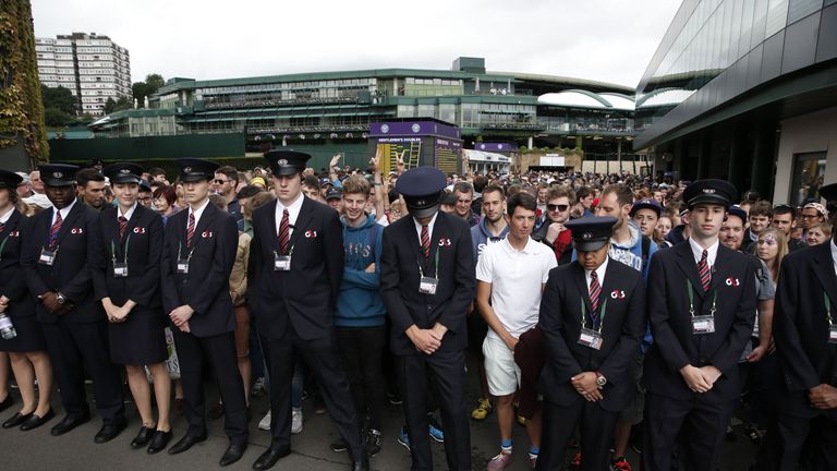 Security hold back spectators as they queue to enter The All England Lawn Tennis Club in Wimbledon, southwest London, on June 27, 2016 on the first day of 