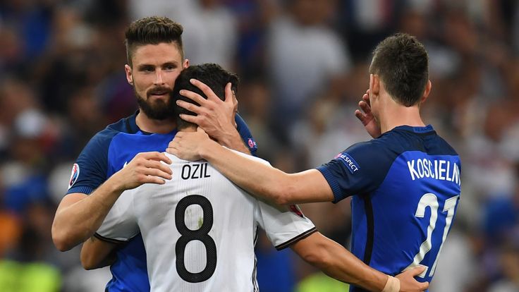 TOPSHOT - France's forward Olivier Giroud (L) and France's defender Laurent Koscielny (R) consol Germany's midfielder Mesut Oezil after France beat Germany