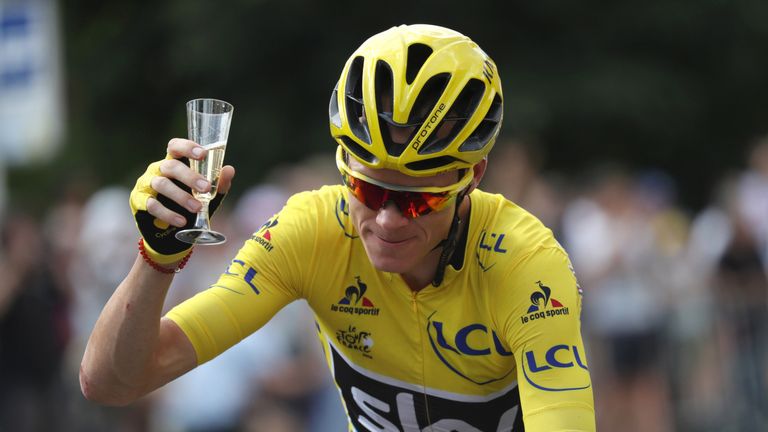 Chris Froome holds a glass of champagne