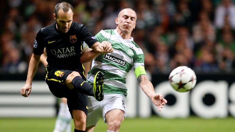 Celtic midfielder Scott Brown (R) challenges Andrea Iniesta of Barcelona in a Champions League match in 2013