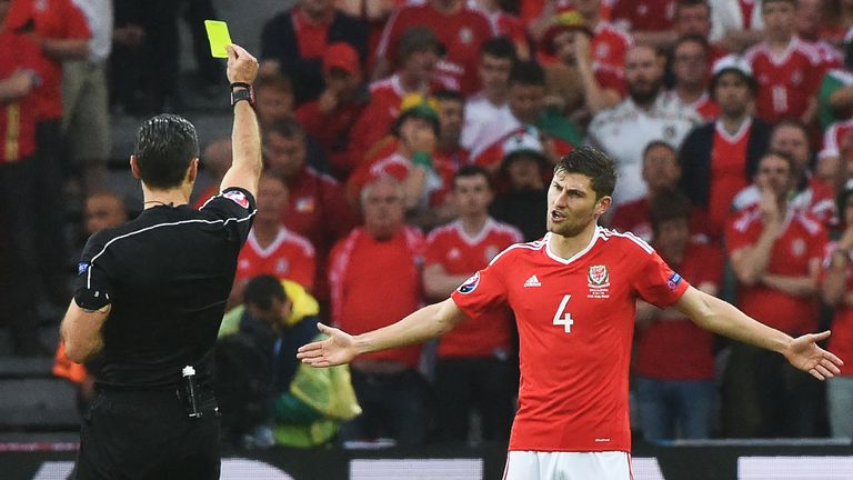 Wales' defender Ben Davies (R) is booked by Slovenian referee Damir Skomina during the Euro 2016 quarter-final football match between Wales and Belgium 