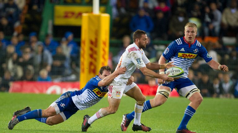 Chiefs' captain Aaron Cruden (C) passes the ball as he is tackled by a Stormers player, during the 2016 Super Rugby quarterfinal play-off match between the