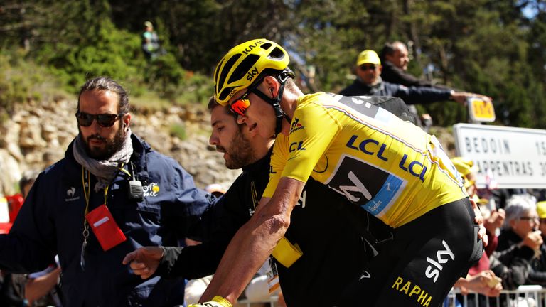 Chris Froome of Great Britain riding for Team Sky wearing the yellow leaders jersey is assisted by a Team Sky support member