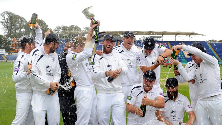 CARDIFF, WALES - SEPTEMBER 25:  The victorious  Hampshire team and staff celebrate with the trophy after winning the Division Two Championship after beatin