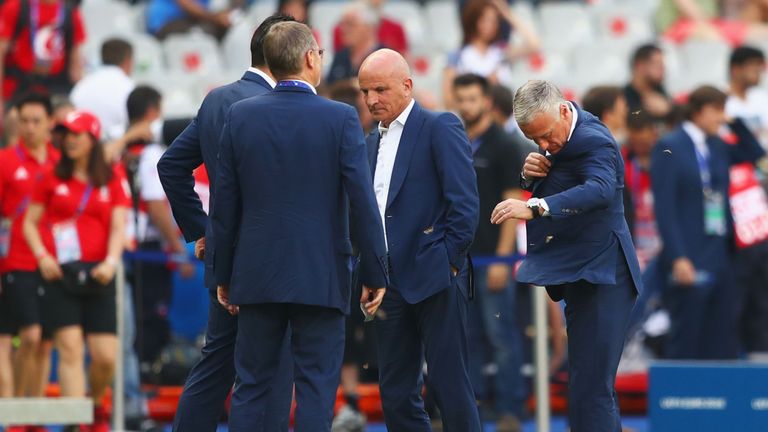 France manager Didier Deschamps (R) tries to brush bugs from his suit ahead of the Euro 2016 final
