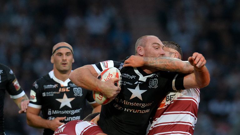 Ellis is tackled by Wigan duo Sean O'Loughlin (left) and Sam Powell