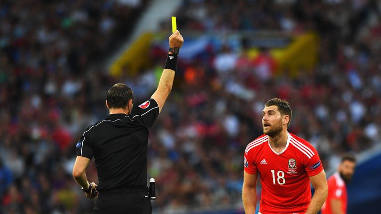 Sam Vokes of Wales is shown a yellow card by referee Jonas Eriksson during the UEFA EURO 2016 Group B match between Russia and Wales