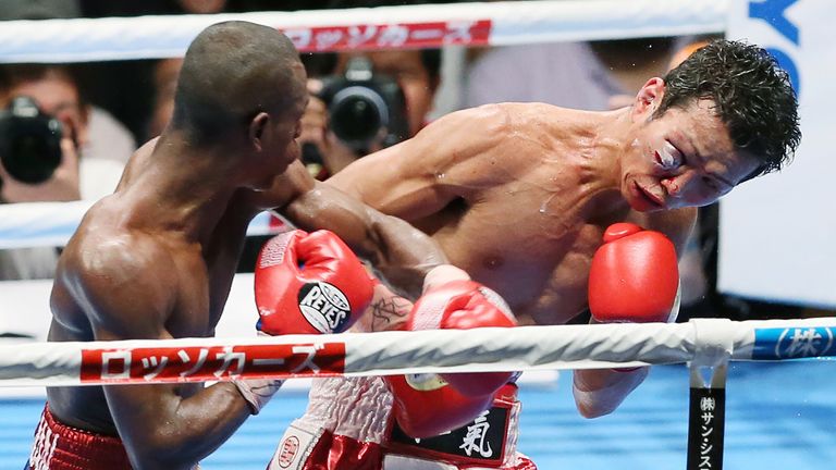 Jonathan Guzman (L) of the Dominican Republic punches Shingo Wake of Japan during their IBF super-bantam weight title boxing bout in Osaka, western Japan o