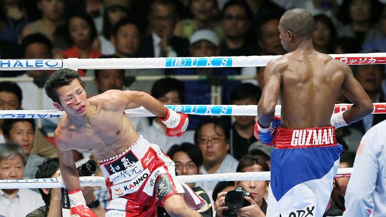 Shingo Wake (L) of Japan staggers after receiving a punch from Jonathan Guzman of the Dominican Republic during their IBF super-bantam weight title boxing 