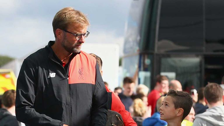 Liverpool manager Jurgen Klopp talks to a young fan as he arrives for a friendly match at Tranmere