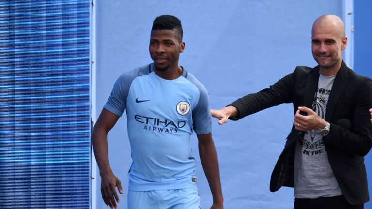 Spanish football manager Pep Guardiola (R) greets Manchester City's Nigerian striker Kelechi Iheanacho (L) as Guardiola is officially unveiled as the club'