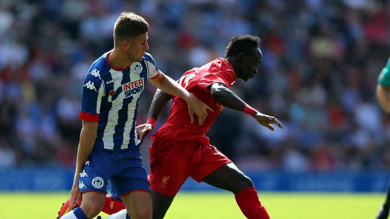 WIGAN, ENGLAND - JULY 17:  Ryan Colclough of (L) Wigan Athletic challenges Sadio Mane of Liverpool during the Pre-Season Friendly match between Wigan Athle