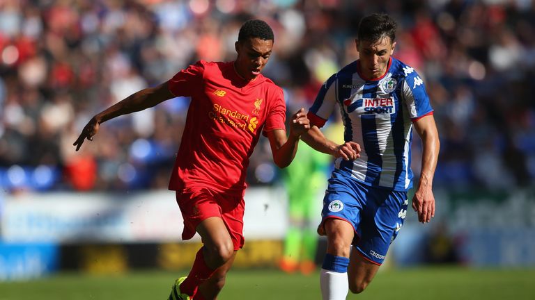WIGAN, ENGLAND - JULY 17:  Jordan Flores of Wigan Athletic and Trent Alexander-Arnold of Liverpool compete for the ball during a pre-season friendly betwee