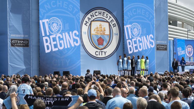 Spanish football coach Pep Guardiola stands with players from various Manchester City squads as he is officially unveiled as the club's new manager at the 