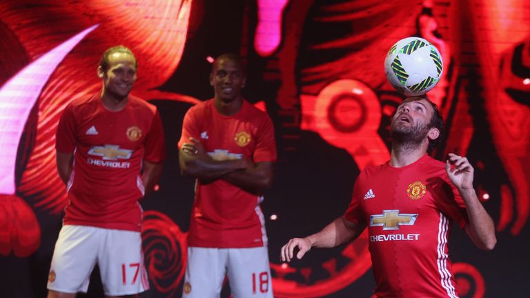 Juan Mata of Manchester United poses during the launch of the 2016/17 Manchester United home kit in Shanghai as Daley Blind and Ashley Young watch on