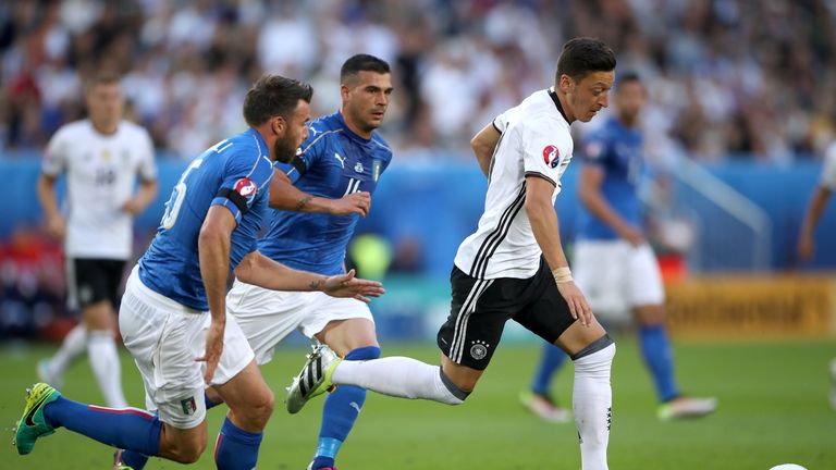 Germany's Mesut Ozil (right) holds off a challenge from Italy's Antonio Candreva and Italy's Stefano Sturaro (centree)