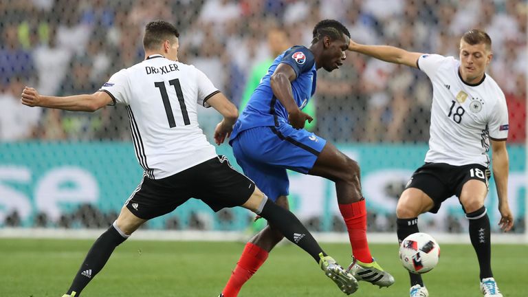 France's midfielder Paul Pogba (C) vies for the ball with Germany's midfielder Julian Draxler (L) and Germany's midfielder Toni Kroos (R) 
