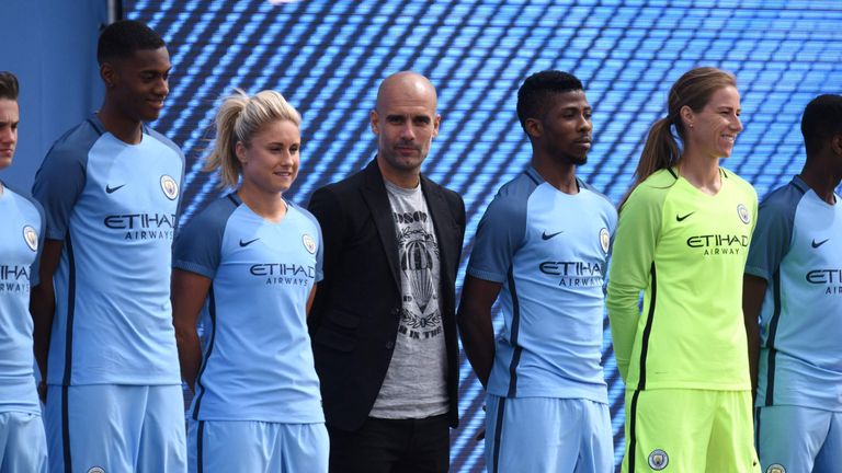Spanish football coach Pep Guardiola (C) stands with players from various Manchester City squads as he is officially unveiled as the club's new manager at 