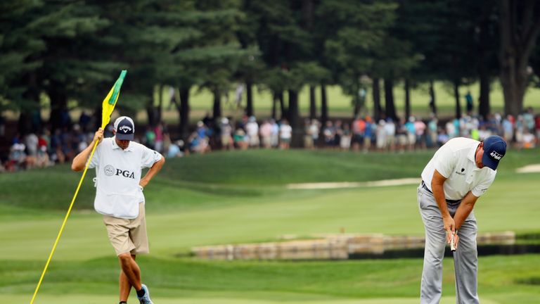 SPRINGFIELD, NJ - JULY 30:  Phil Mickelson of the United States putts on the 18th green as caddie Jim 'Bones' Mackay holds the flag during the third round 