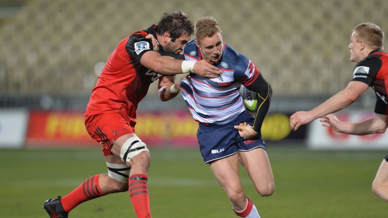 Reece Hodge of the Rebels is tackled by Samuel Whitelock of the Crusaders during the round 16 Super Rugby match betwee
