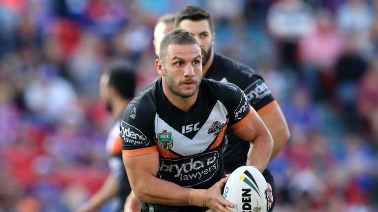 Robbie Farah of the Tigers runs the ball against the Newcastle Knights