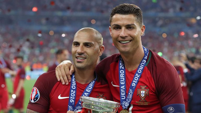 Portugal's forward Cristiano Ronaldo (R) and Portugal's forward Ricardo Quaresma pose with the trophy as they celebrate after beating France 