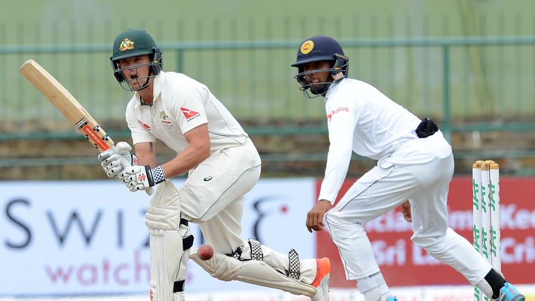 Australia's Steve O'Keeffe (L) plays a shot as Sri Lanka's Kusal Mendis (R) look on during the fifth and the final day of their opening Test match between 