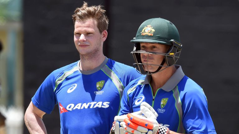 Australian cricket team captain Steven Smith (L) and his teammate David Warner watch others during a practice session at the Warner Park stadium in Bassete
