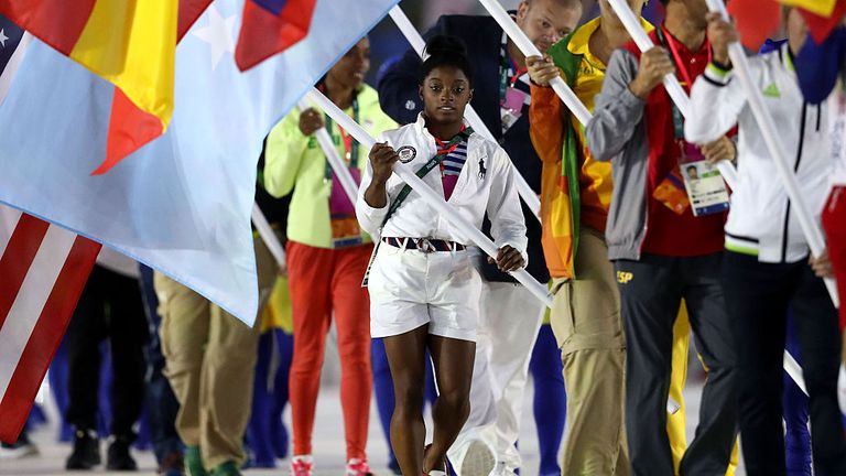 Simone Biles carries the US flag at the closing ceremony for the Rio Olympics