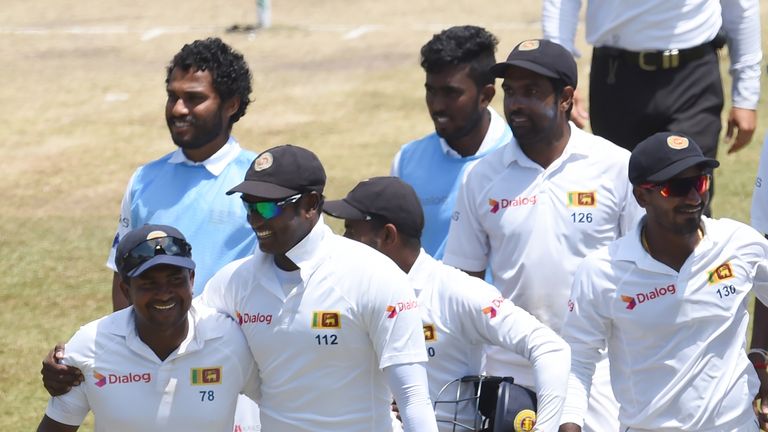 Sri Lanka's captain Angelo Mathews, (C), cricketer Rangana Herath (L) and teammates leave the grounds with the stumps after victory in the second Test matc