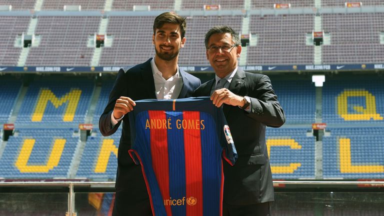 New Barcelona's Portuguese forward Andre Gomes(L) poses with his new jersey beside Barcelona's president Josep Maria Bartomeu (R) on the pitch in 2016