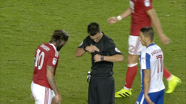 Referee Andre Madley can't find his cards as he goes to book Henri Lansbury.